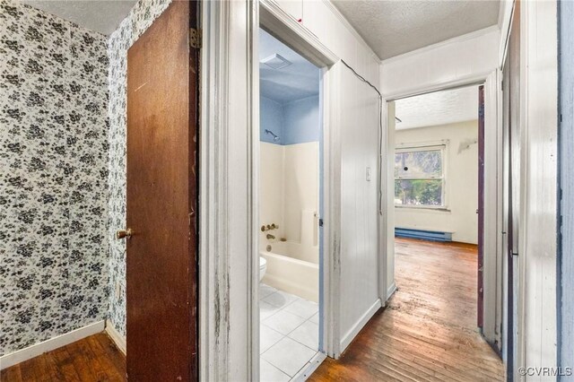 507 Tavern St, Blackstone, VA 23824 - hall featuring wood finished floors, wallpapered walls, a textured ceiling, and a baseboard radiator