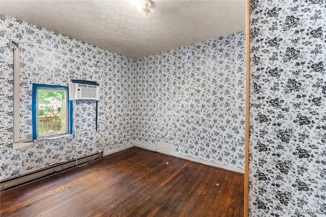 507 Tavern St, Blackstone, VA 23824 - spare room featuring wallpapered walls, dark wood-style floors, baseboard heating, a textured ceiling, and a wall mounted air conditioner
