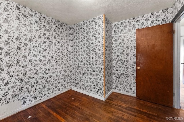 507 Tavern St, Blackstone, VA 23824 - empty room featuring wallpapered walls, hardwood / wood-style flooring, and a textured ceiling