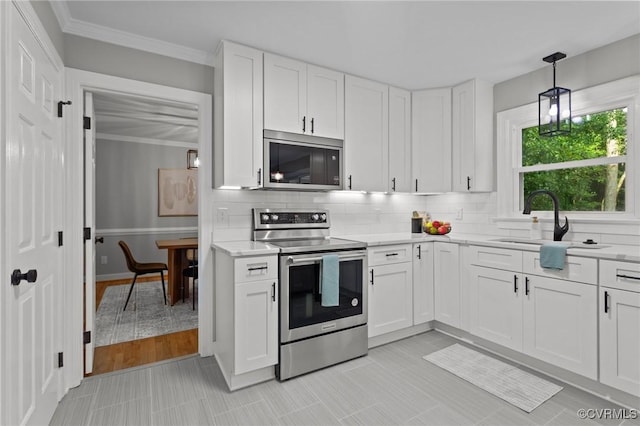 2941 Ellesmere Dr, Midlothian, VA 23113 - kitchen featuring appliances with stainless steel finishes, white cabinetry, backsplash, crown molding, and hanging light fixtures