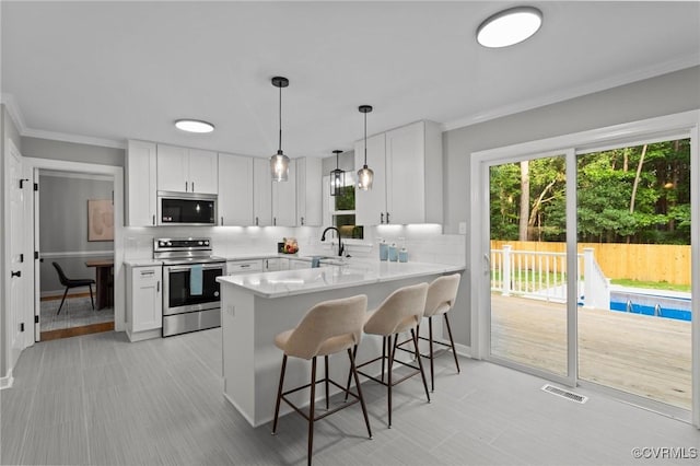 2941 Ellesmere Dr, Midlothian, VA 23113 - kitchen with stainless steel appliances, light countertops, a kitchen breakfast bar, tasteful backsplash, and a peninsula