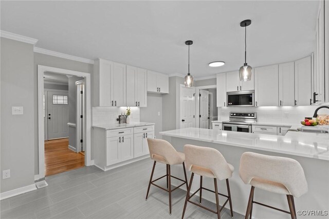 2941 Ellesmere Dr, Midlothian, VA 23113 - kitchen featuring stainless steel appliances, tasteful backsplash, ornamental molding, a peninsula, and light countertops