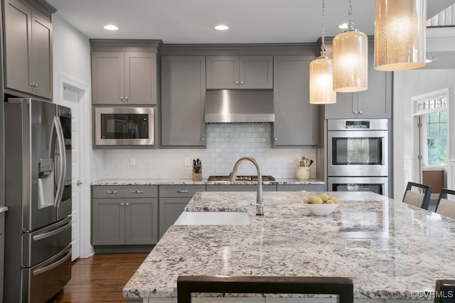 8300 Mckibben Dr, Chesterfield, VA 23838 - kitchen featuring stainless steel appliances, gray cabinets, exhaust hood, dark wood-type flooring, and decorative backsplash