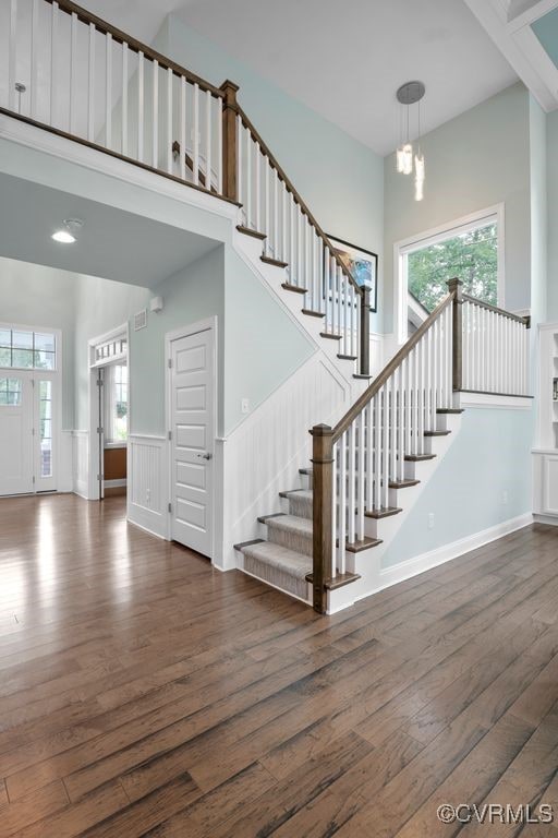 8300 Mckibben Dr, Chesterfield, VA 23838 - staircase featuring wood finished floors, a towering ceiling, a wainscoted wall, and a chandelier