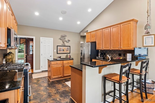405 Elm Creek Dr, Manakin Sabot, VA 23103 - kitchen featuring appliances with stainless steel finishes, a peninsula, tasteful backsplash, vaulted ceiling, and recessed lighting