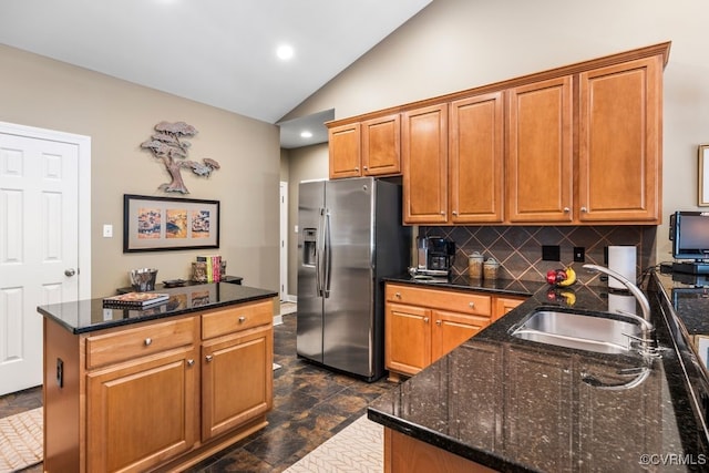 405 Elm Creek Dr, Manakin Sabot, VA 23103 - kitchen with stainless steel fridge, vaulted ceiling, decorative backsplash, dark stone countertops, and brown cabinets