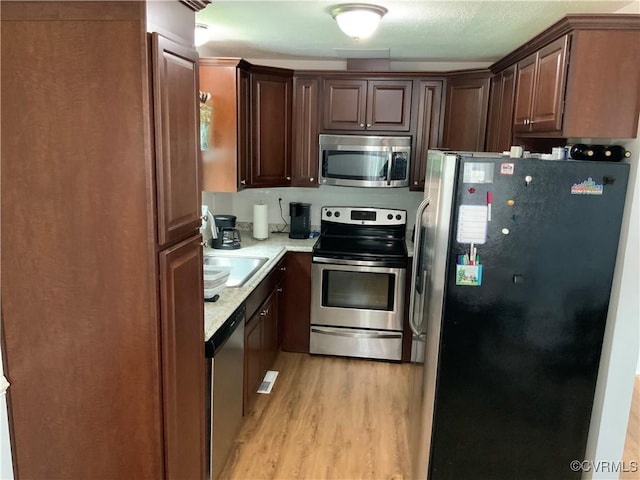12400 Richmond St, Chesterfield, VA 23831 - kitchen with stainless steel appliances, light wood finished floors, and dark brown cabinetry