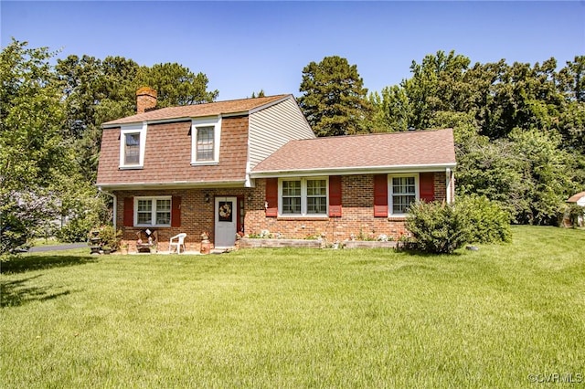 25014 James Ave, Dinwiddie, VA 23803 - view of front of home featuring a gambrel roof, a chimney, a front yard, brick siding, and roof with shingles