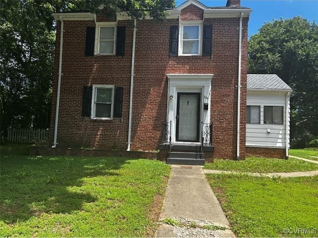 1041 Welton Ave, Richmond, VA 23224 - townhome / multi-family property featuring a front lawn, brick siding, and a chimney