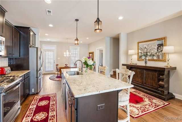 14432 Michaux Village Dr, Midlothian, VA 23113 - kitchen featuring stainless steel appliances, a kitchen bar, wood finished floors, an island with sink, and recessed lighting