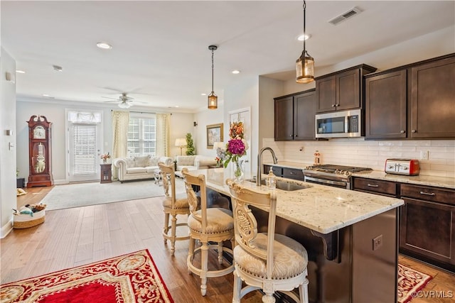 14432 Michaux Village Dr, Midlothian, VA 23113 - kitchen with appliances with stainless steel finishes, dark brown cabinets, backsplash, ceiling fan, and light wood finished floors