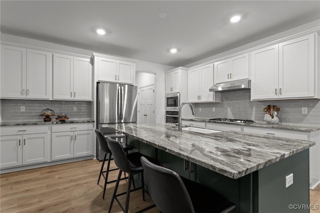 8507 Mckibben Dr, Chesterfield, VA 23838 - kitchen featuring stainless steel appliances, under cabinet range hood, tasteful backsplash, a kitchen breakfast bar, and recessed lighting