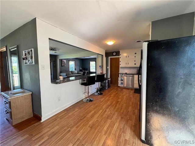 7360 Ford Ave, Mechanicsville, VA 23111 - kitchen with freestanding refrigerator, light wood-style flooring, white cabinetry, and plenty of natural light