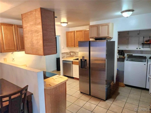 5724 Linda Rd, Sandston, VA 23150 - kitchen with appliances with stainless steel finishes, light tile patterned floors, independent washer and dryer, and light countertops