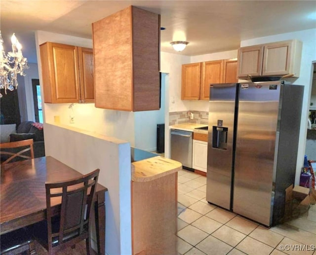 5724 Linda Rd, Sandston, VA 23150 - kitchen with appliances with stainless steel finishes, a chandelier, light countertops, light tile patterned floors, and a peninsula