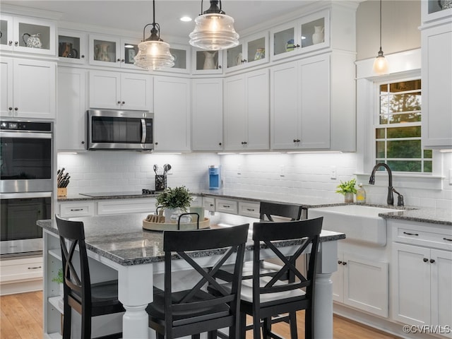 1270 Mill Quarter Rd, Powhatan, VA 23139 - kitchen featuring appliances with stainless steel finishes, white cabinetry, decorative backsplash, and light wood-style floors