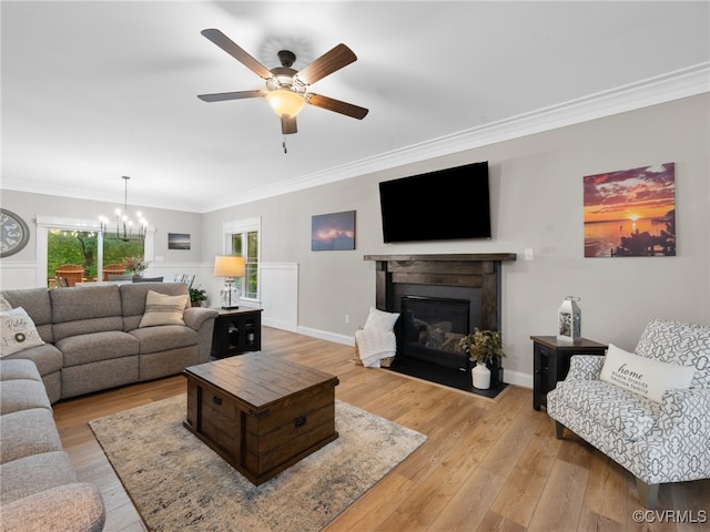 1270 Mill Quarter Rd, Powhatan, VA 23139 - living room featuring crown molding, light wood-type flooring, ceiling fan, a chandelier, and a glass covered fireplace