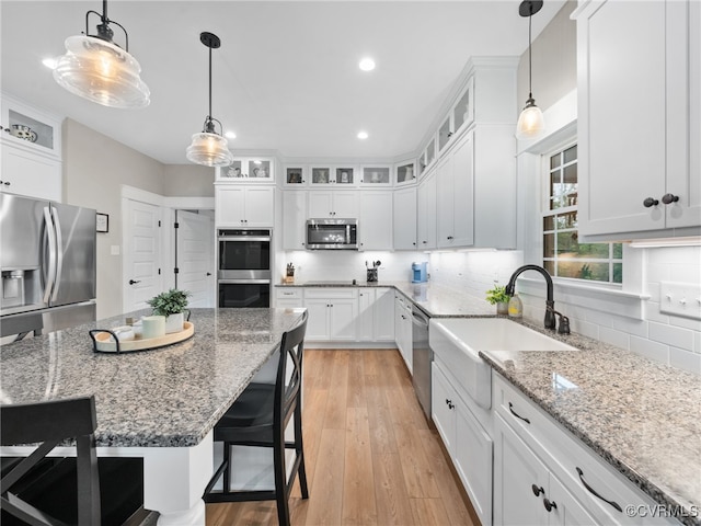 1270 Mill Quarter Rd, Powhatan, VA 23139 - kitchen featuring appliances with stainless steel finishes, a kitchen breakfast bar, recessed lighting, white cabinets, and light wood-style floors