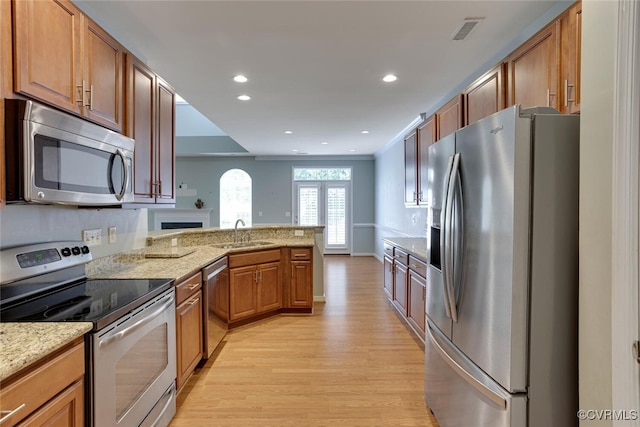 5027 Lewisetta Dr, Glen Allen, VA 23060 - kitchen featuring appliances with stainless steel finishes, light wood-type flooring, a peninsula, recessed lighting, and light stone counters