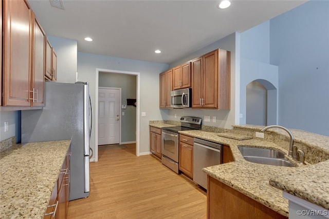 5027 Lewisetta Dr, Glen Allen, VA 23060 - kitchen featuring appliances with stainless steel finishes, light wood finished floors, light stone counters, recessed lighting, and brown cabinetry