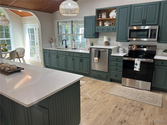 111 New S Rd, Lancaster, VA 22482 - kitchen featuring appliances with stainless steel finishes, light wood-type flooring, arched walkways, hanging light fixtures, and open shelves