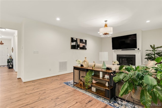 6112 Water Violet Ter, Moseley, VA 23120 - living area featuring light wood finished floors, a chandelier, recessed lighting, and a glass covered fireplace