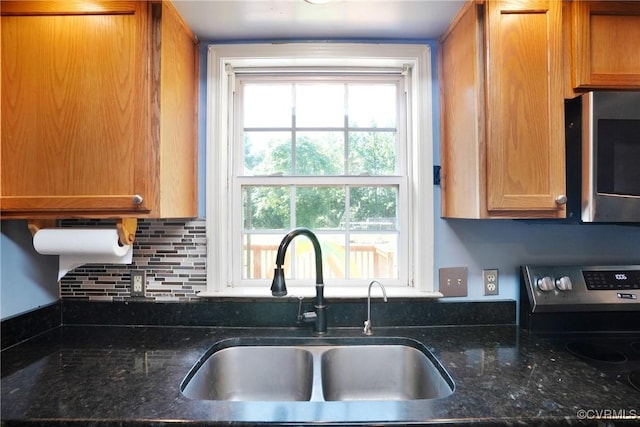 291 Briery Hills Dr, Meherrin, VA 23954 - kitchen featuring stainless steel microwave, decorative backsplash, dark stone countertops, and brown cabinetry