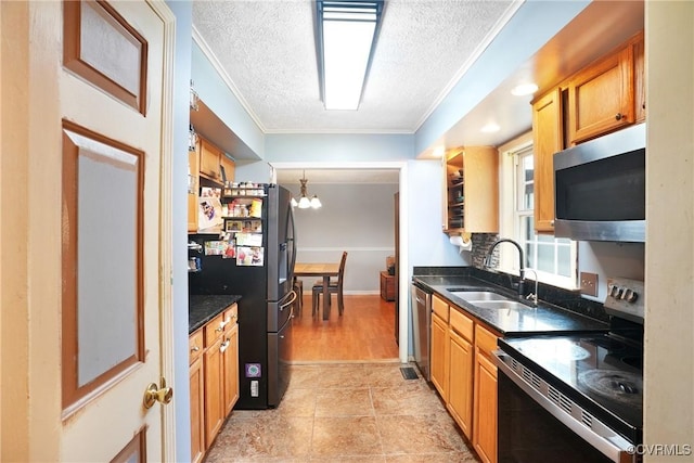 291 Briery Hills Dr, Meherrin, VA 23954 - kitchen featuring stainless steel appliances, a textured ceiling, crown molding, a chandelier, and brown cabinetry