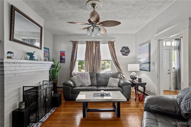 306 Hamilton Ave, Colonial Heights, VA 23834 - living room with ceiling fan, wood finished floors, a textured ceiling, and a brick fireplace