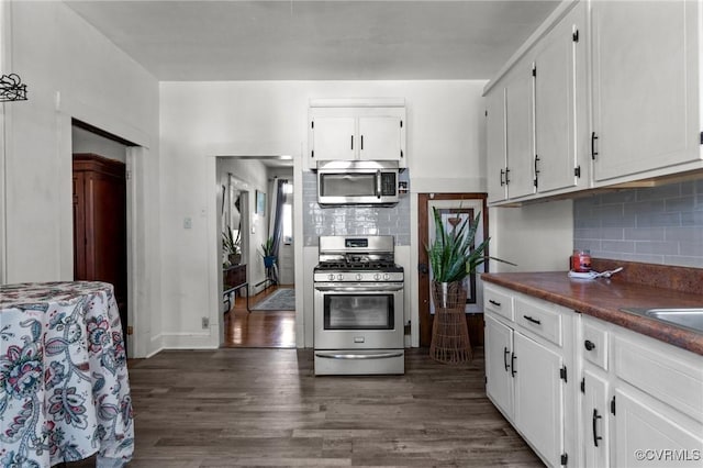 306 Hamilton Ave, Colonial Heights, VA 23834 - kitchen featuring stainless steel appliances, white cabinetry, dark countertops, dark wood finished floors, and decorative backsplash