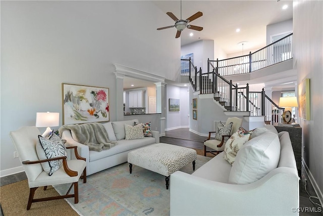 6430 Arwen Mews, Moseley, VA 23120 - living room featuring a towering ceiling, wood finished floors, ceiling fan, stairway, and ornate columns