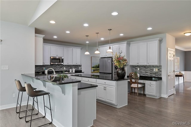 6430 Arwen Mews, Moseley, VA 23120 - kitchen with appliances with stainless steel finishes, a peninsula, decorative backsplash, dark wood-style floors, and recessed lighting