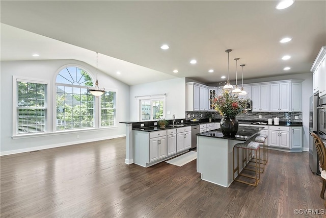6430 Arwen Mews, Moseley, VA 23120 - kitchen with dark countertops, dishwasher, decorative backsplash, a peninsula, and vaulted ceiling