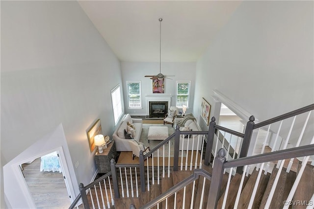 6430 Arwen Mews, Moseley, VA 23120 - stairs featuring a glass covered fireplace, wood finished floors, high vaulted ceiling, and ceiling fan
