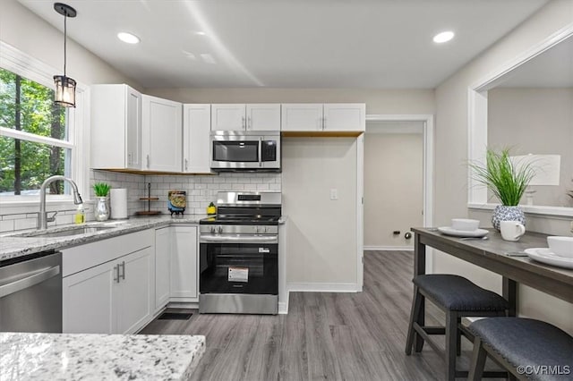 2718 Colgrave Rd, Chesterfield, VA 23112 - kitchen featuring appliances with stainless steel finishes, white cabinetry, light stone counters, wood finished floors, and decorative backsplash