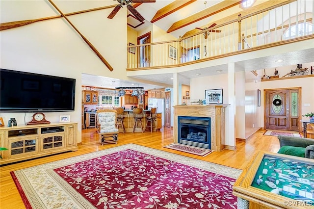 716 W Riverside Dr, Lanexa, VA 23089 - living room with wood finished floors, a ceiling fan, a towering ceiling, and a glass covered fireplace