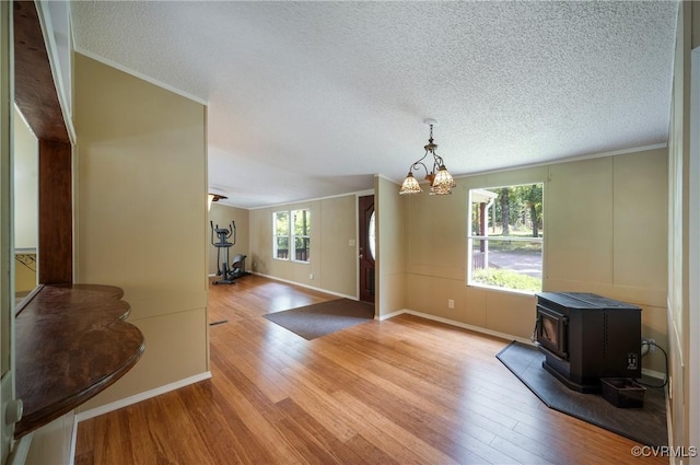 454 Elam Forest Dr, Prospect, VA 23960 - unfurnished dining area with wood finished floors, a wood stove, a chandelier, crown molding, and a textured ceiling