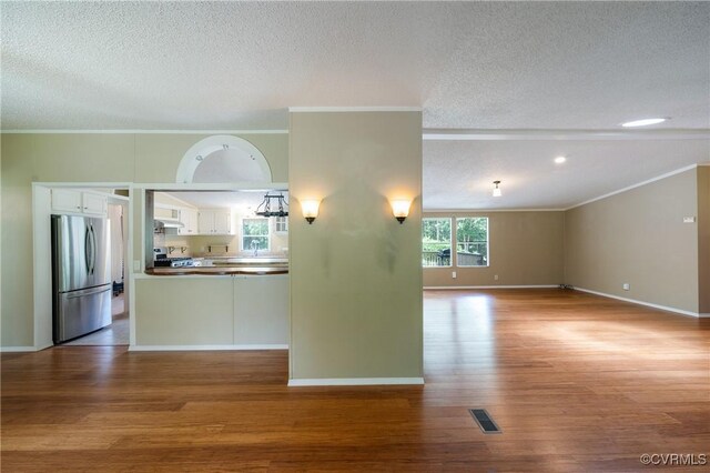 454 Elam Forest Dr, Prospect, VA 23960 - unfurnished living room featuring wood finished floors, ornamental molding, and a textured ceiling