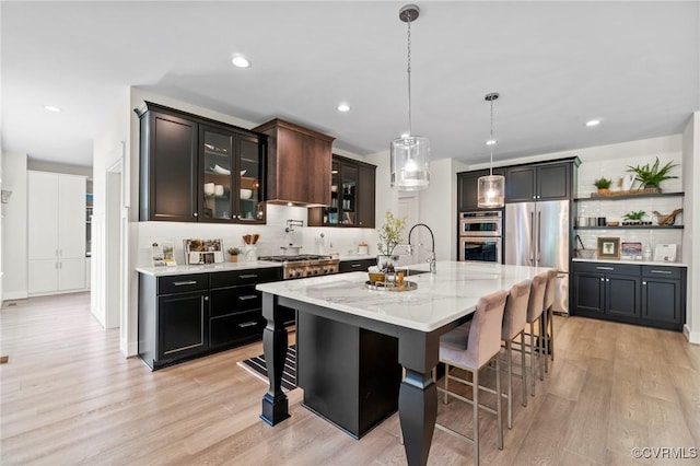 TBD Cedar Lane, Glen Allen, VA 23059 - kitchen with stainless steel appliances, decorative backsplash, a breakfast bar area, light wood finished floors, and light stone countertops