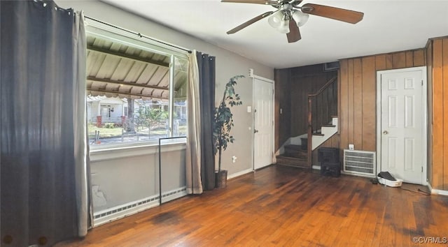 17 E 31st St, Richmond, VA 23224 - unfurnished bedroom featuring baseboard heating, wood finished floors, a ceiling fan, and wooden walls