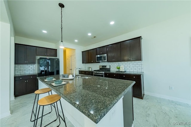 5311 Benmable Ct, Glen Allen, VA 23059 - kitchen featuring appliances with stainless steel finishes, backsplash, a breakfast bar, dark brown cabinetry, and a center island with sink