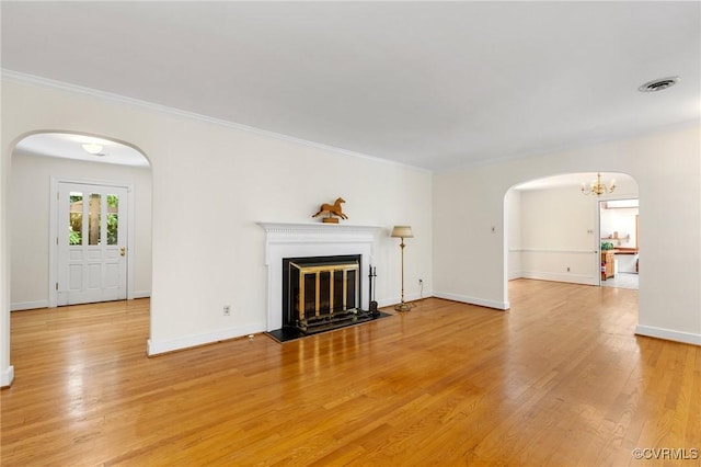 7800 Wood Rd, Henrico, VA 23229 - unfurnished living room with arched walkways, a chandelier, light wood-style floors, ornamental molding, and a fireplace with flush hearth