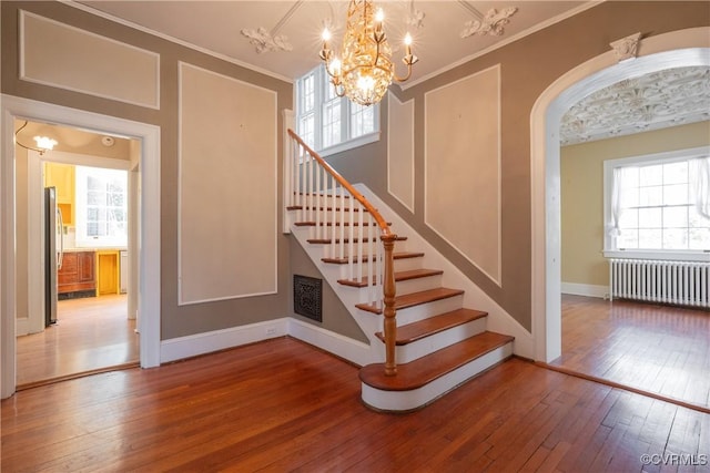 1602 Brandon Ave, Petersburg, VA 23805 - staircase featuring radiator, hardwood / wood-style floors, a chandelier, ornamental molding, and arched walkways