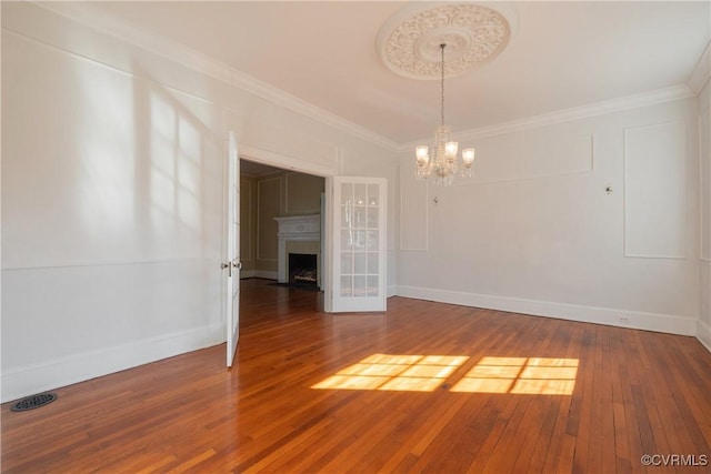 1602 Brandon Ave, Petersburg, VA 23805 - spare room with a chandelier, hardwood / wood-style floors, a fireplace with flush hearth, and ornamental molding