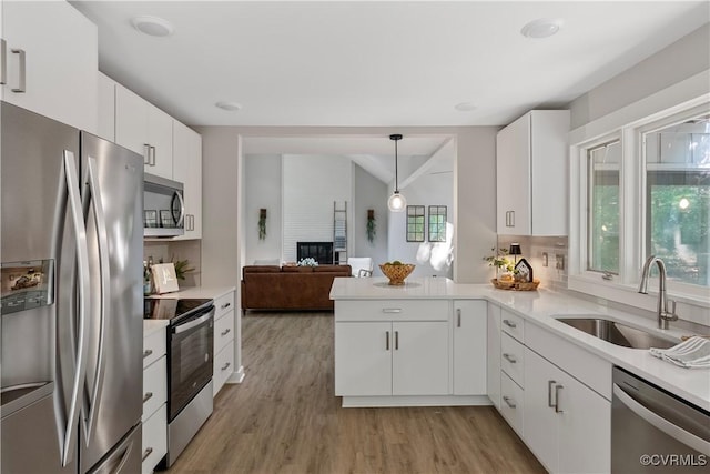 4458 Old Fox Trl, Chesterfield, VA 23112 - kitchen with stainless steel appliances, a fireplace, light countertops, light wood finished floors, and white cabinetry