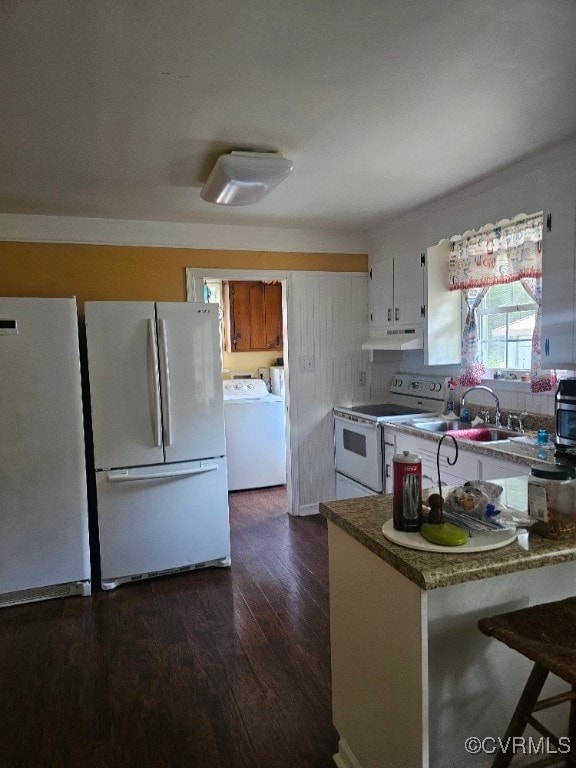 5403 Chesdin Rd, North Dinwiddie, VA 23803 - kitchen with white appliances, under cabinet range hood, dark wood finished floors, white cabinetry, and washing machine and dryer