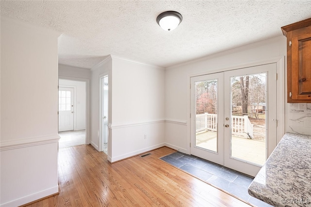 6924 Longview Dr, New Kent, VA 23141 - unfurnished dining area featuring light wood-style flooring, french doors, a textured ceiling, and crown molding