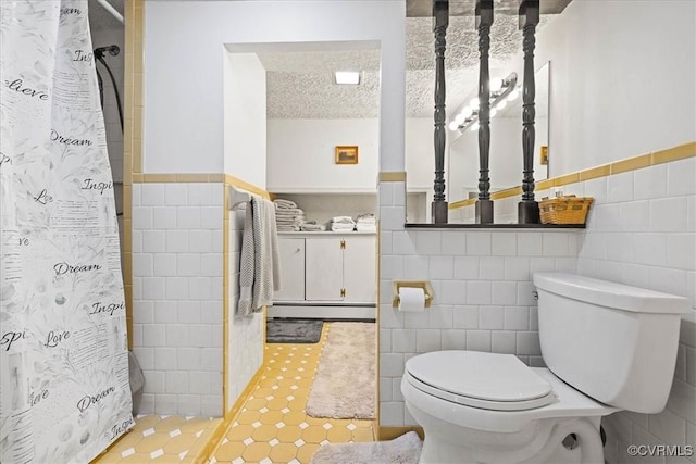 4312 Erlene Ct, Chester, VA 23831 - full bath featuring tile walls, baseboard heating, wainscoting, a shower with shower curtain, and tile patterned flooring