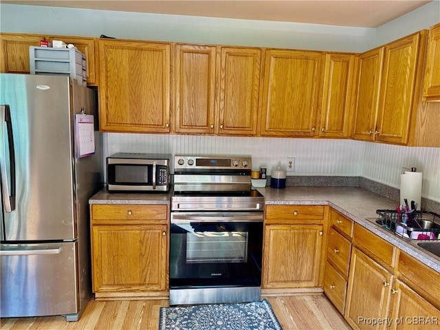 162 Twin Oaks Rd, Water View, VA 23180 - kitchen with stainless steel appliances, brown cabinetry, and light wood finished floors