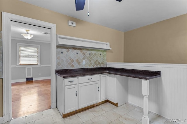 3205 Birchbrook Rd, Henrico, VA 23228 - kitchen with white cabinets, ceiling fan, dark countertops, backsplash, and light tile patterned floors
